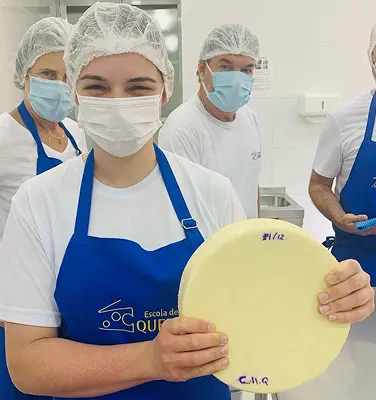 Imagem de aluno da Escola de Queijos segurando queijo
